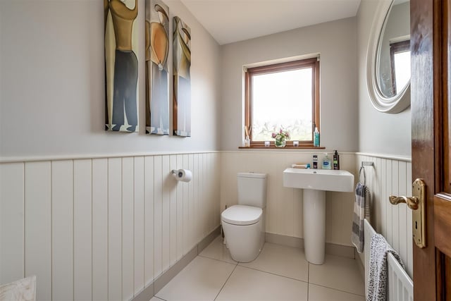 Cloakroom with contemporary, white, two-piece suite comprising pedestal wash hand basin and WC.