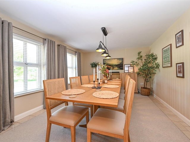 Beautifully presented formal dining room with tiled flooring, a bespoke hand made carpet inset and feature wall panelling.
