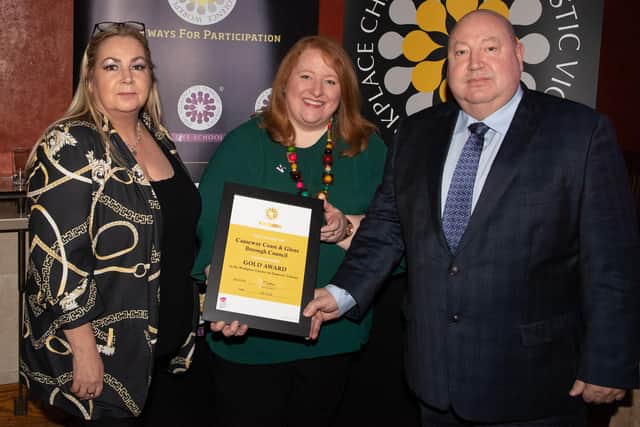 The Chair of Causeway Coast and Glens Policing and Community Safety Partnership, Alderman Adrian McQuillan, receives the Onus Gold Workplace Charter Award from Naomi Long, along with PCSP member Patricia McQuillan
