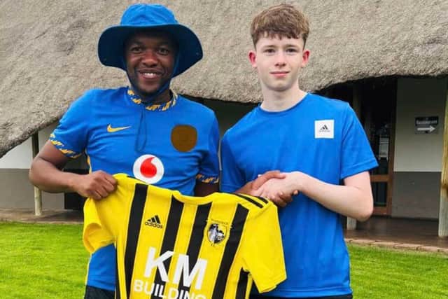 Lewis Magee presents the Seapatrick kit to Tsepho Mojapelo, from Mzansi Soccer.
