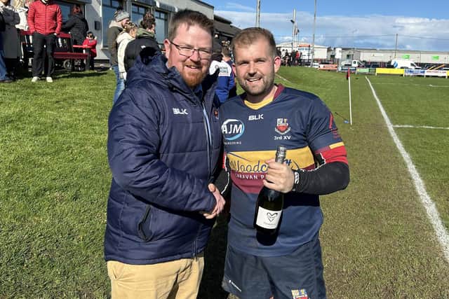 Andrew Craig, the last Banbridge player to captain a Crawford Plate winning side, presents Alan Thompson with a celebratory bottle.