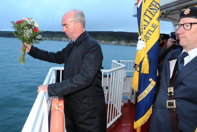 Commander Rob Milligan, Royal Navy, lays a wreath at sea at HMS Drake at Rathlin island Bay