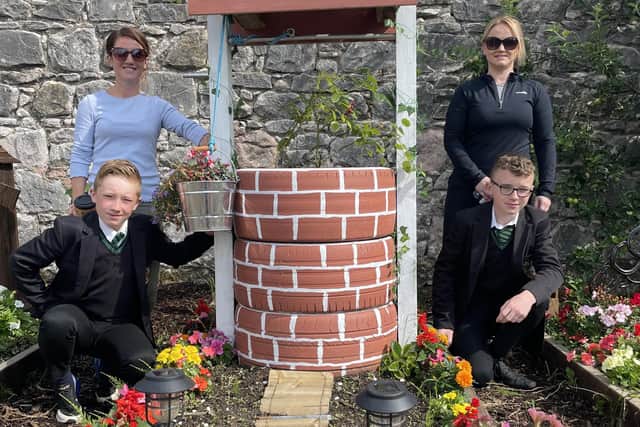 The Well, adorned with vibrant flowers, ranked highly in each category of the voting. Dominic and Caolan along with their key adult Dearbhail, are congratulated for their innovative thinking and team work to lift first place in the flowerbed competition. Credit: Holy Trinity College