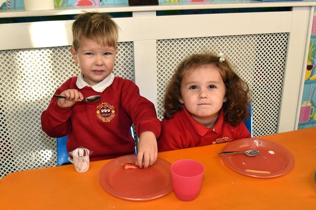 Enjoying their mid-morning break at Kids United Playgroup are pupils, James and Addie. PT99-223.