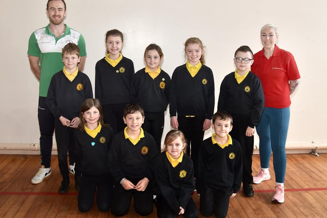 Northern Ireland and Ireland swimmer, David Thompson and Bex Hamilton from Sports For Schools pictured with some of the pupils of Hart Memorial Primary School during their exercise programme, Athlete For A Day. PT11-220.