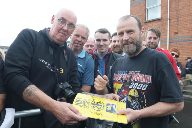 TT legend Bruce Anstey autographs a programme for fans during the Joey Dunlop 25 Celebration in his home town of Ballymoney.