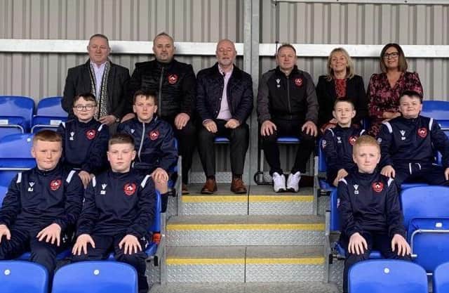 Pictured are Brian Sofley, Managing Director, ASSA ABLOY, Chris Budd, Director of the Lisburn Castlereagh Junior Football League, Andy Tough, Chief Executive, Inspire Business Centre, Chris Finlay, Head Coach, Alderman Amanda Grehan, Janet Little, Boomer Industries, and some of the young players.