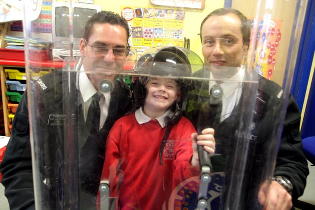 SHIELDED. Little Jenna a pupil at the Eden PS finds herself well guarded behind a riot shield and flanked by Consts Paul Le Fondre and David Mitchell when they - along with Sgt Elliott - visited the school in 2010 to talk about investigation and observation skills.