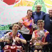 The players and coaches pictured with the silverware.