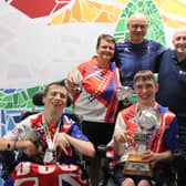 The players and coaches pictured with the silverware.