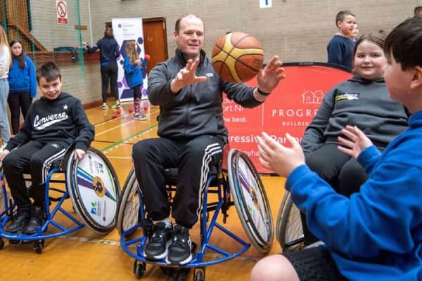 Communities Minister Gordon Lyons tries his hand at wheelchair basketball. Credit Department for Communities