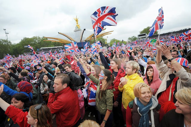 Crowds in front of Buckingham Palace in London wave flags as Queen Elizabeth II makes an appearance on the balcony for her Diamond Jubilee celebrations.