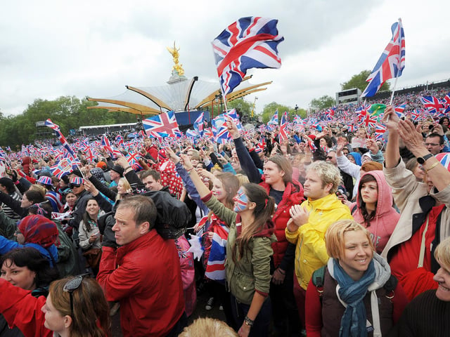 Crowds in front of Buckingham Palace in London wave flags as Queen Elizabeth II makes an appearance on the balcony for her Diamond Jubilee celebrations.