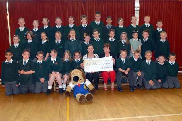 Janice Ireland and Hector the Dog from Help the Aged receive a cheque for £500 from pupils at St Brendan's Primary School in June 2007 who raised the money through various activities. Included is Mrs Theresa O'Hagan, pricipal.