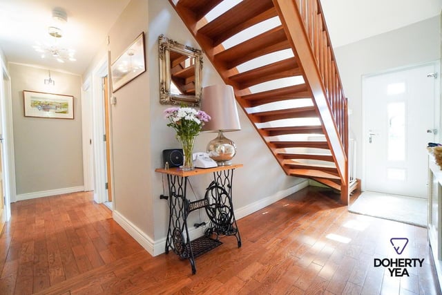 Hallway with solid oak flooring, built in storage, and mahogany open tread stairs to the first floor.