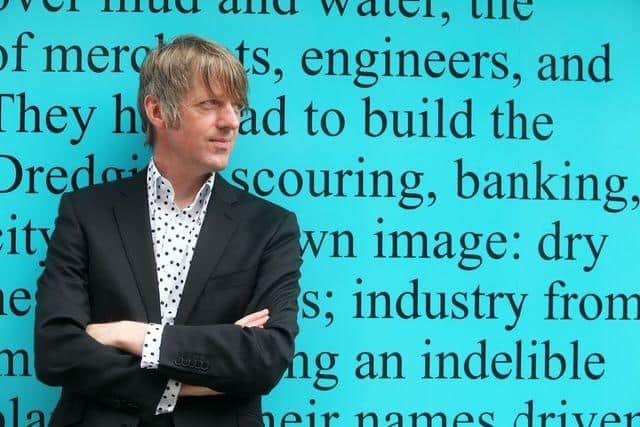Author Glenn Patterson leans against the backdrop of a quote from his debut novel, 'Fat Lad.'