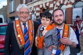 Three generations in orange...Thomas Hanna , left, is pictured with his great grandson, Kai Matchett and grandson Jordan Matchett at the Portadown Mini 12th parade on Saturday night. PT24-216.