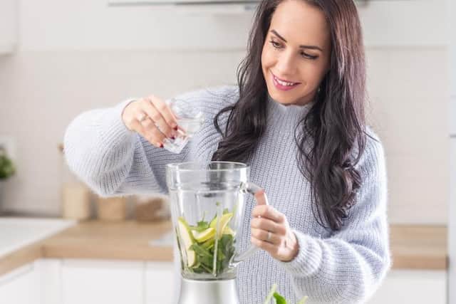 A woman adds water into a mixer for a spinach, banana, and apple smoothie.  The new superfood Macha's Orchard powder can be used in smoothies or sprinkled on porridge. Developed by Richmount Rural Community Association near Portadown, Co Armagh, the powder is professed to have beneficial health qualities.