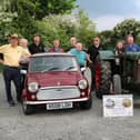 Seven year old Aine Fegan tries out the driving seat of a 1942 Fordson tractor as Dromara Vintage and Classic Club prepare for their June all-vehicle road run in aid of charity. Pictured from left are Club members Brian McGrillen (President), Griff Morrow, John Fitzpatrick, George McNeill, Peter McGrady, Stan Gratton, Stephen McCann, David Thompson and James Fegan. Pic credit: Dromara Vintage Club