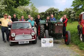 Seven year old Aine Fegan tries out the driving seat of a 1942 Fordson tractor as Dromara Vintage and Classic Club prepare for their June all-vehicle road run in aid of charity. Pictured from left are Club members Brian McGrillen (President), Griff Morrow, John Fitzpatrick, George McNeill, Peter McGrady, Stan Gratton, Stephen McCann, David Thompson and James Fegan. Pic credit: Dromara Vintage Club