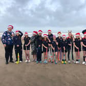 Pictured holding onto their Santa hats during their sea dip debut on Portstewart Strand are the brave Year 8 pupils from Coleraine Grammar School; Amber Miller, Anna McGreevy, Elise Archibald, Erin Semple, Eva Grace Patterson, Isabella McCarron, Jasmine Moore, Jessica Cartmill, Josie Dixon, Lucy Blackstock, Poppy Ewing, Sarah McCaughey and Tilly Lyttle. Also included are Mr Semple, Mr Cartmill and mayor of Causeway Coast and Glens, councillor Steven Callaghan