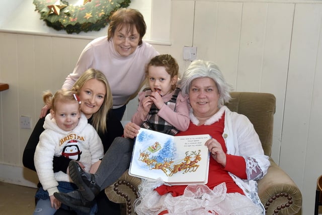 Enjoying a story from Mrs Claus at the Knitted Knockers Christmas Market are from left, Ellie Davison (3), mum Rachel, gran Sylvia and Paige (5). PT51-208.