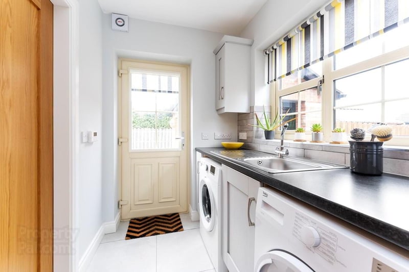 The utility room has a range of high and low level storage units, space for washing machine and tumble dryer, a stainless steel sink and drainer and tiled floor and splashback.
