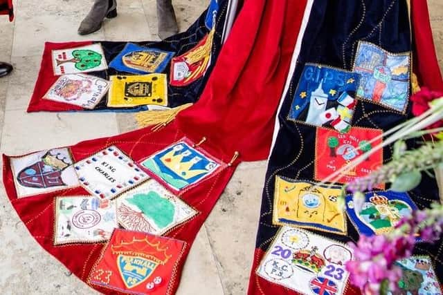 The robe's colourful patches were created by local primary schools.