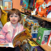 Aliana Wilkinson (2) chooses a favorite book at the new Waterstones store at Rushmere with the help of mum, Diane. PT41-208.
