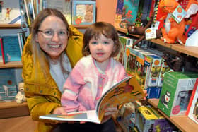 Aliana Wilkinson (2) chooses a favorite book at the new Waterstones store at Rushmere with the help of mum, Diane. PT41-208.