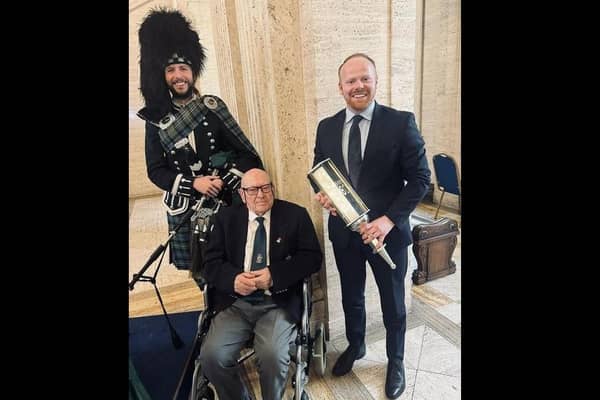 D-Day veteran and Carrickfergus man George Horner pictured with piper, Grahame Harris and East Antrim MLA John Stewart at Parliament Buildings for the 'Lighting their Legacies' event, part of the 80th Anniversary of D-Day commemorations.  Photo: John Stewart MLA
