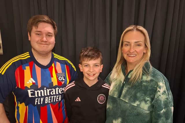Jack Cranston, who will be playing the Beast in Lisnagarvey Operatic Society's Beauty and the Beast, with brother Sam, who is in the chorus, and mum Claire who is playing Madame de la Grande Bouche. Pic credit: LODS