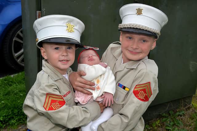 Young Drumaderg Flute Band members, Jack Robertson (3) and Tommy Morrow (9) pictured with four-month-old Darcy Robertson at the Mavemacullen Accordion Band 70th anniversary parade in Markethill on Wednesday evening. PT32-228.