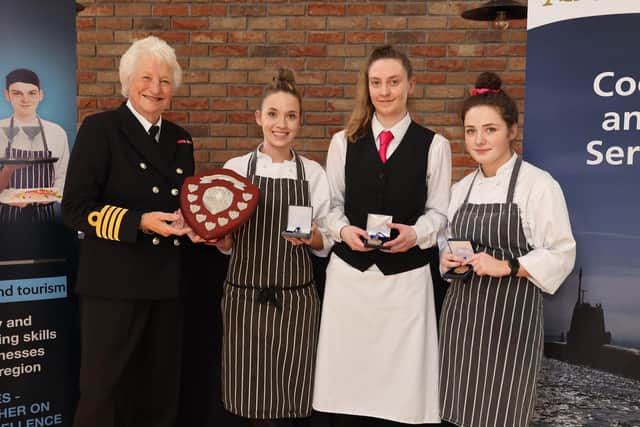 The winners from South Eastern Regional College, Nadia Rainey, Eimer McCarthy and Erin Horner, receive their gold medals from Lady Mary Peters.