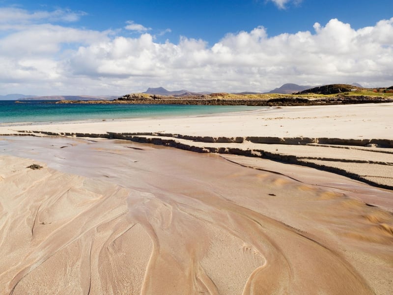 Gaze at distant Highland mountains across Gruinard Bay from this spectacular beach, with its fine silver sands, gentle dunes, and crystal clear waters. It is a hidden gem in Wester Ross, in the north west of Scotland.