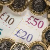 UK five pound, ten pound, twenty pound and fifty pound notes with one pound coins.