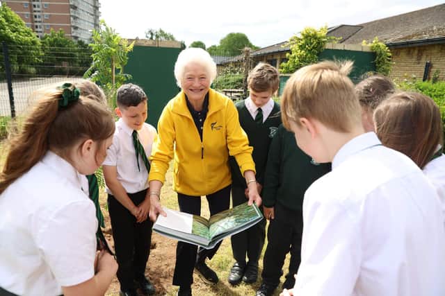 Lady Mary Peters showing Finaghy PS pupils a book about the Queen's Green Canopy