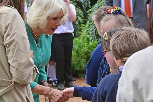 A special moment as Queen Camilla stops to say ' hello' to one of the school pupils gathered at Hazelbank Park. Picture: Colm Lenaghan/Pacemaker