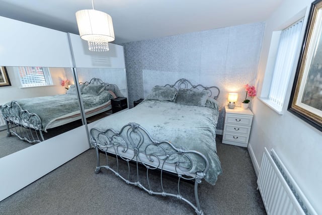 Master bedroom featuring range of fitted robes with mirrored sliding doors.
