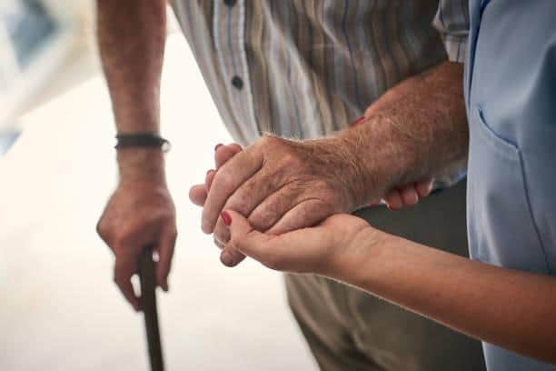 Female nurse supporting senior man to walk. Credit: Dean Mitchell/Getty Images
