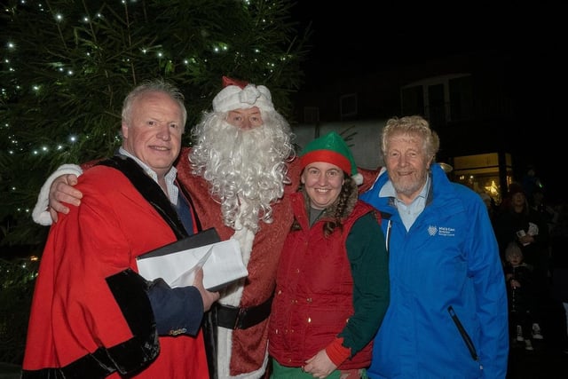 Santa and his helper with Councillors Robin Stewart (left) and Robin Logan at the switching on of Whitehead's Christmas lights.