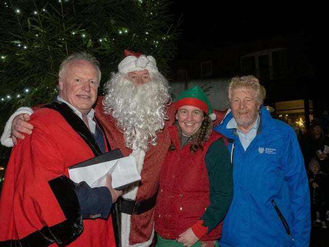Santa and his helper with Councillors Robin Stewart (left) and Robin Logan at the switching on of Whitehead's Christmas lights.