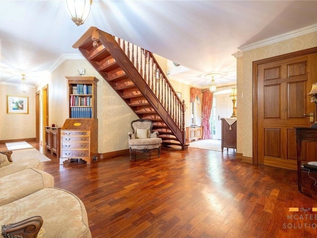 Elegant entrance hall featuring a wooden front door and solid wooden flooring.