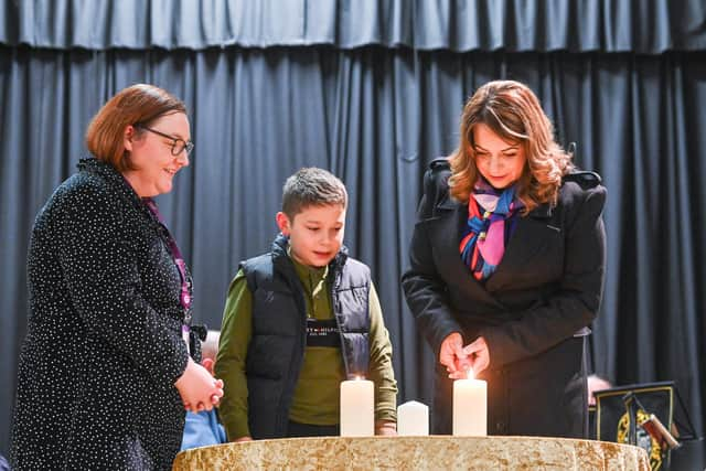 NI Hospice Social Worker Aislinn Delaney, with Conor and Grainne Parkhill, light the candles at NI Hospice's Lights to Remember.  Photo: Simon Graham Photography