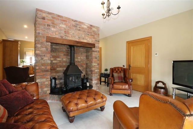 The tastefully finished open plan living area has a solid wood burner stove with curved granite hearth in feature brick surround and a reclaimed oak beam.