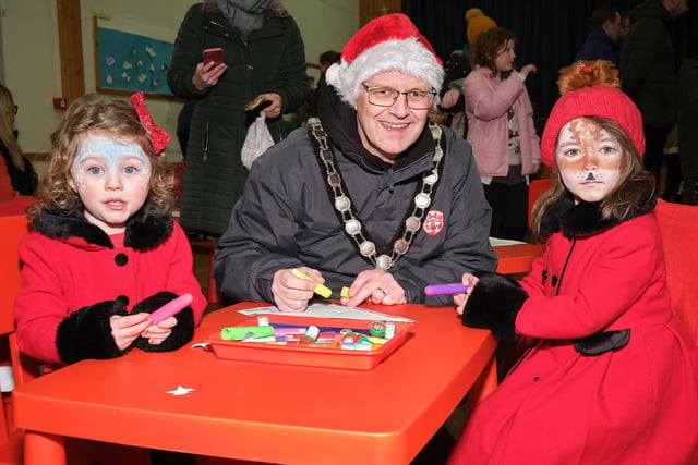 Chair of Mid Ulster District Council, Councillor Dominic Molloy, helps some of the children with their festive artwork.