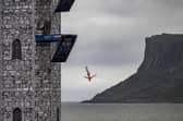 Pierrick Schafer of Switzerland dives from the 27 metre platform during the final competition day of the fourth stop of the 2024 Red Bull Cliff Diving World Series at Ballycastle Harbour, Causeway Coast, Northern Ireland on July 20, 2024.
