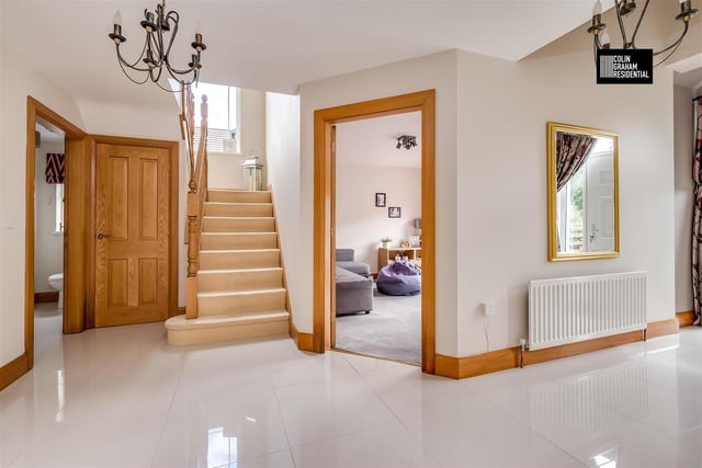 The entrance hall was a composite, panelled front door with PVC double glazed side screens and a fan light over, with a tiled floor and access to an under-stairs store.