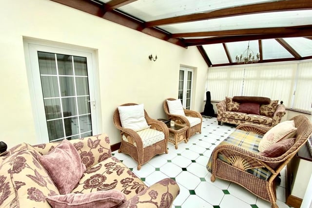 The large conservatory is P shaped and has  French doors leading to the rear garden.