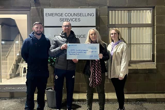 Members of Lambeg Orange and Blue Flute Band present a donation cheque to Samantha Evans from Emerge Counselling Services